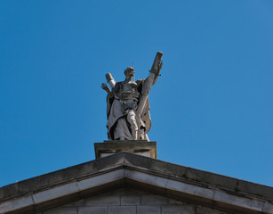 Fototapeta na wymiar St. Andrew Statue auf dem Giebel einer Kirche