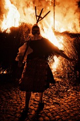 traditional woman participant of the busojaras event in front of the large bonfire