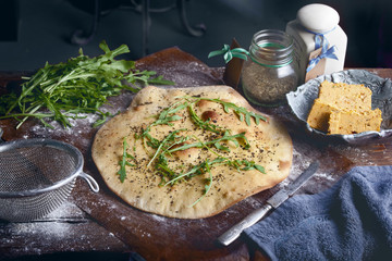 italian food preparation background with focaccia, butter, ruccola salad and spices