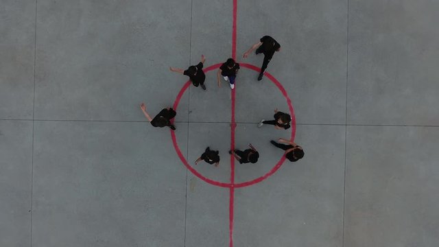 Group Of Kids Cheering In Circle Drone View. Vertical Aerial