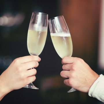 Man and Woman hands toasting with Champagne
