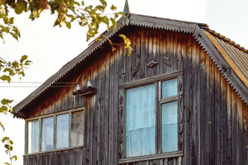 Fototapeta na wymiar Fragment of an old wooden house. Roof window and roof.