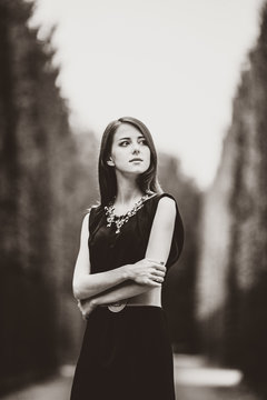 Beautiful woman in black dress in versailles gardens. Image in black and white color style