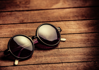 Fototapeta na wymiar Retro sunglasses on wooden table. Side view
