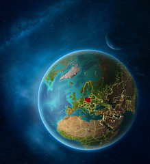 Planet Earth with highlighted Poland in space with Moon and Milky Way. Visible city lights and country borders.