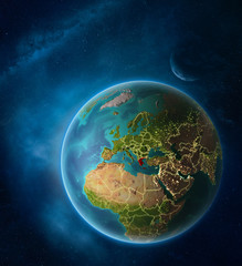 Planet Earth with highlighted Greece in space with Moon and Milky Way. Visible city lights and country borders.