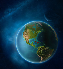 Planet Earth with highlighted Cuba in space with Moon and Milky Way. Visible city lights and country borders.