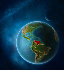 Planet Earth with highlighted Venezuela in space with Moon and Milky Way. Visible city lights and country borders.