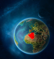 Planet Earth with highlighted Algeria in space with Moon and Milky Way. Visible city lights and country borders.