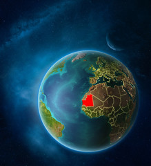 Planet Earth with highlighted Mauritania in space with Moon and Milky Way. Visible city lights and country borders.