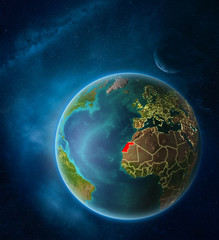 Planet Earth with highlighted Western Sahara in space with Moon and Milky Way. Visible city lights and country borders.