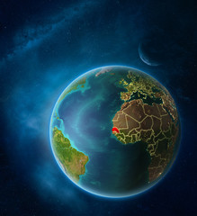 Planet Earth with highlighted Senegal in space with Moon and Milky Way. Visible city lights and country borders.
