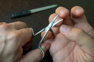 cut your fingernails with small nail scissors, nail file on the back blurred background