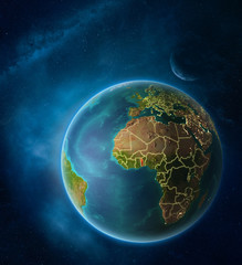 Planet Earth with highlighted Togo in space with Moon and Milky Way. Visible city lights and country borders.