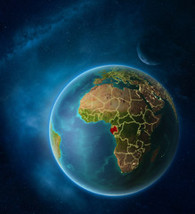 Planet Earth with highlighted Gabon in space with Moon and Milky Way. Visible city lights and country borders.