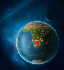 Planet Earth with highlighted Botswana in space with Moon and Milky Way. Visible city lights and country borders.