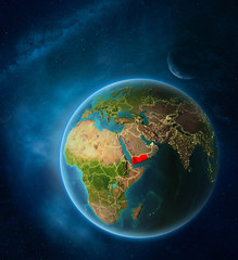 Planet Earth with highlighted Yemen in space with Moon and Milky Way. Visible city lights and country borders.