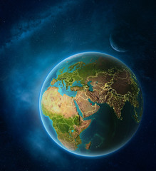 Planet Earth with highlighted Qatar in space with Moon and Milky Way. Visible city lights and country borders.