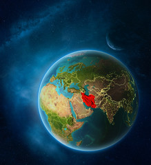 Obraz na płótnie Canvas Planet Earth with highlighted Iran in space with Moon and Milky Way. Visible city lights and country borders.
