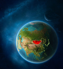 Planet Earth with highlighted Mongolia in space with Moon and Milky Way. Visible city lights and country borders.