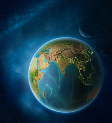 Planet Earth with highlighted Sri Lanka in space with Moon and Milky Way. Visible city lights and country borders.
