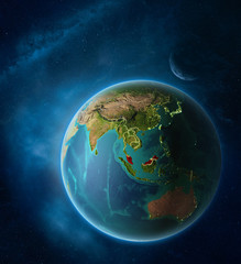 Planet Earth with highlighted Malaysia in space with Moon and Milky Way. Visible city lights and country borders.