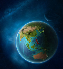 Planet Earth with highlighted Philippines in space with Moon and Milky Way. Visible city lights and country borders.
