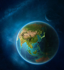 Fototapeta na wymiar Planet Earth with highlighted Taiwan in space with Moon and Milky Way. Visible city lights and country borders.
