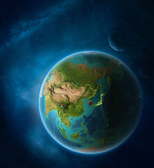 Planet Earth with highlighted South Korea in space with Moon and Milky Way. Visible city lights and country borders.