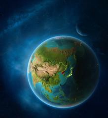 Planet Earth with highlighted North Korea in space with Moon and Milky Way. Visible city lights and country borders.