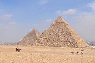 Fototapeta na wymiar Tourists horseback riding in front of the Pyramids of Giza, Egypt