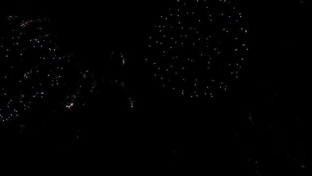 Bright colorful fireworks turn to multicolor bokeh lights at holiday dark summer night.