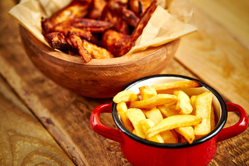top view of delicious fried chicken wings and french fries on old wooden table