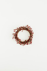 Wreath frame made of red berries on white background. Flat lay, top view Christmas / New Year festive mock up template.
