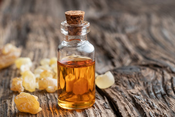 A bottle of frankincense essential oil with frankincense crystals