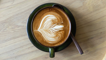 Cappuccino on a wooden coffee table in a coffee shop in Thailand