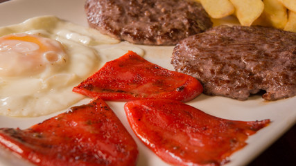 Fried egg with hamburguers, red pepper and chips