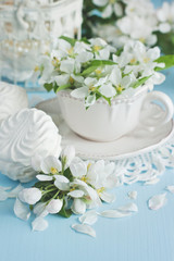 Fototapeta na wymiar Spring flowers background with tea cup and sweet cookies