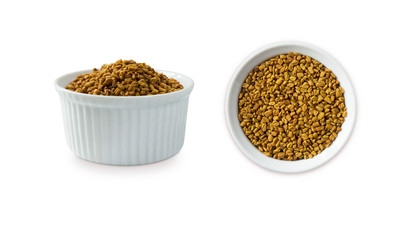 Fenugreek seeds in a wooden bowl isolated on white. Fenugreek seeds isolated on white background. Fenugreek with copy space for text.