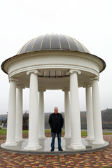 Man posing on background of rotunda in autumn - obrazy, fototapety, plakaty
