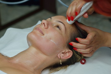 young woman during cosmetic facial treatment