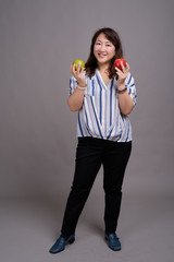 Full length portrait of Japanese businesswoman against gray background