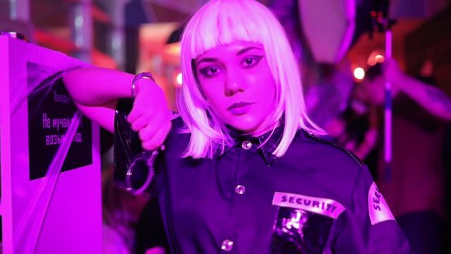 Sexy security woman in a nightclub gnaws handcuffs