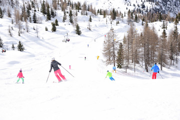 ski slope with skiers in the Alps
