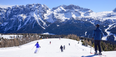 ski slope with skiers in the Alps