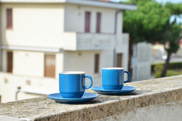 Two blue cups of coffee with panoramic view of a city in background. on the balcony against the backdrop of the old European city. good morning, romance