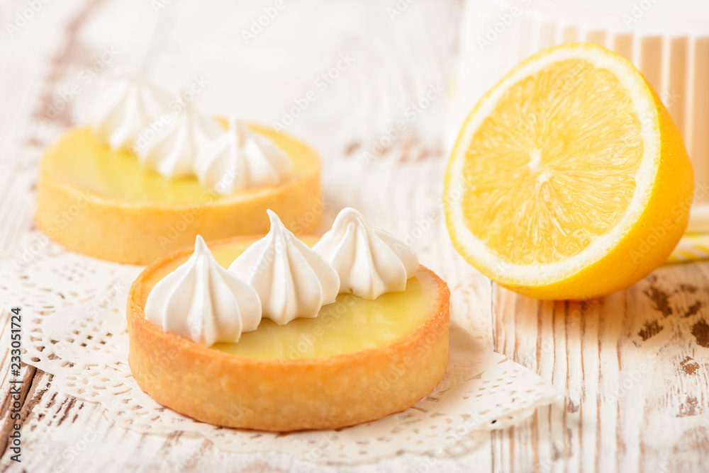 Wall mural Lemon pie on the table with citrus fruits. Traditional french sweet pastry tart. Delicious, appetizing, homemade dessert with lemon curd cream. Copy space