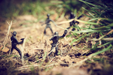 Soldiers in jungle fighting. Concept image of toy plastic soldiers in real grass.  Selective focus.