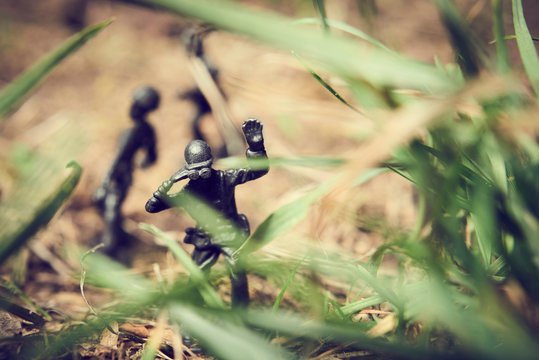 Soldiers in jungle fighting. Concept image of toy plastic soldiers in real grass.  Selective focus.