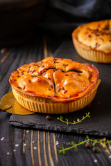 Meat mini pie on the wooden board on table background, closeup with copy space, rustic style